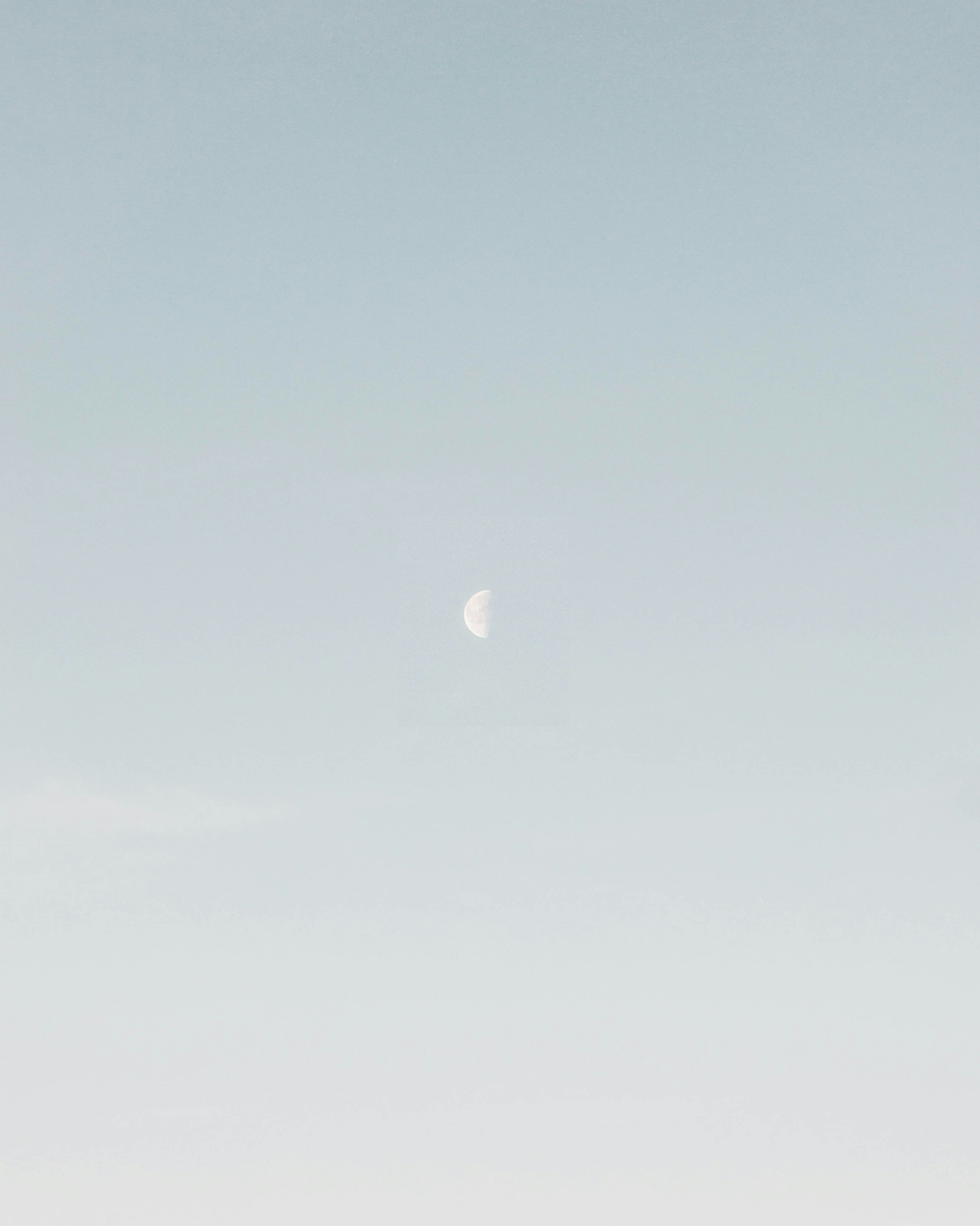photo of half-moon during daytime